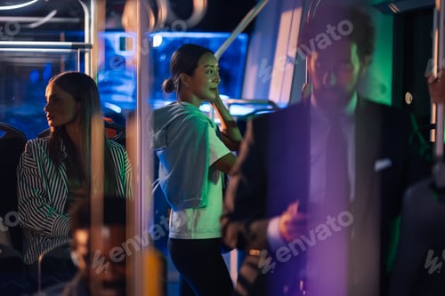 Preview: Young woman standing on a moving bus at night with passengers