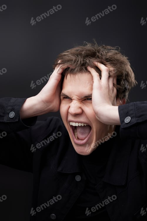 Preview: annoyed angry man in furious gesture on black background