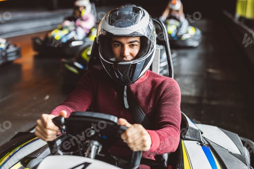 Preview: Focused Go-Kart Racer in Helmet Ready for Action