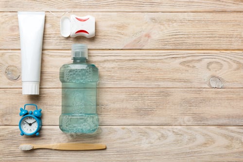 Preview: Mouthwash and other oral hygiene products on colored table top view