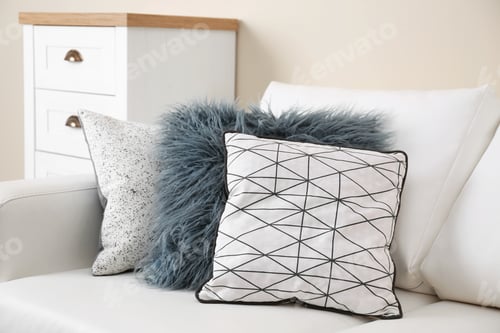 Preview: Different soft pillows on sofa in room. Interior element