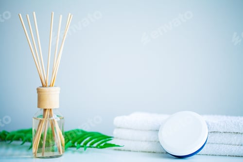 Preview: Spa concept. Moisturizing cream, towels and aroma oil on table in bath room