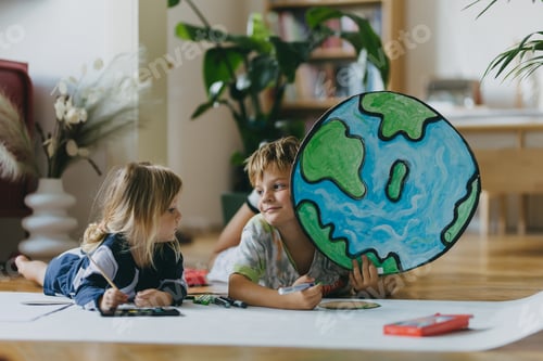 Preview: Siblings lying on stomach and painting at home with watercolors and tempera paints, creating a model