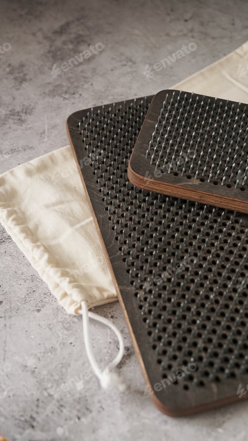 Preview: Dark sadhu board made of wood with nails. Vertical photo on a marble background