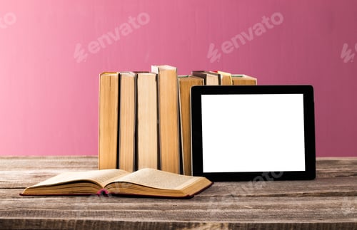 Preview: Books and tablet placed on wooden table against a pink background in a cozy reading corner
