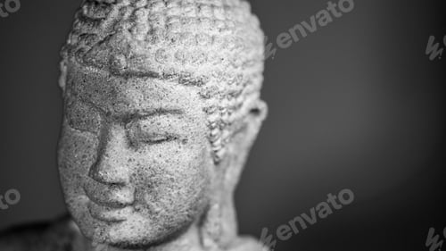 Preview: Close-up of a serene Buddha statue in grayscale, highlighting texture and detail.