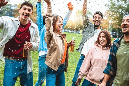 Preview: Group of friends enjoying party throwing confetti in the air