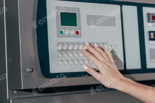 Preview: Woman's Hand Operating Industrial Machine in Workplace Setting