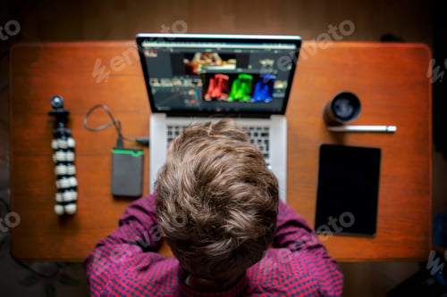 Preview: male producer edit video on his laptop in studio b
