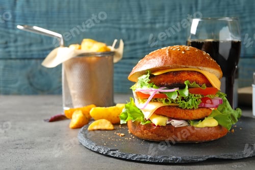 Preview: Slate plate with double vegetarian burger on table. Space for text