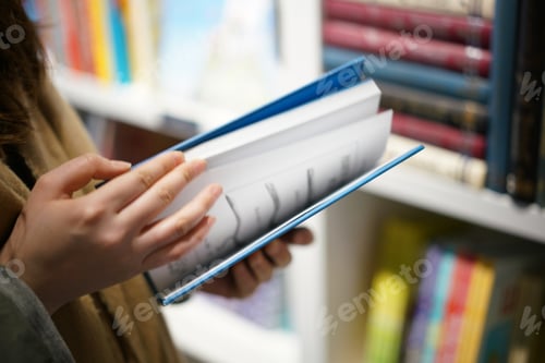Preview: Girl holding a hardcover book in a bookstore