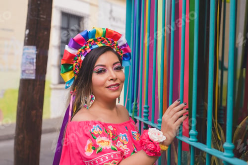 Preview: Mexican woman wearing embroidered dress and Lele doll headband. Outdoor portrait.