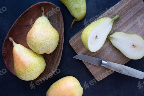 Preview: Whole pears fill a small plate, while juicy halves on a cutting board.