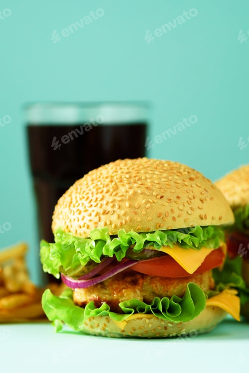Preview: Fast food concept. Juicy homemade hamburgers on blue background. Take away meal. Unhealthy diet