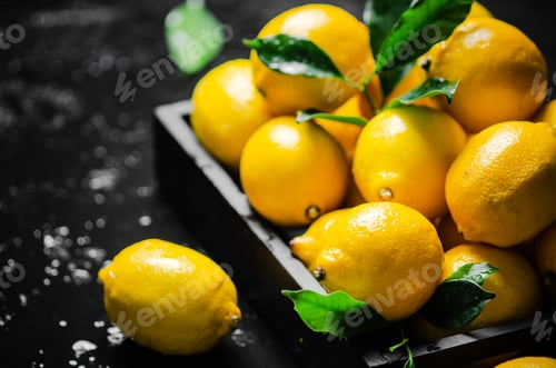 Preview: Fresh lemons. On black table.