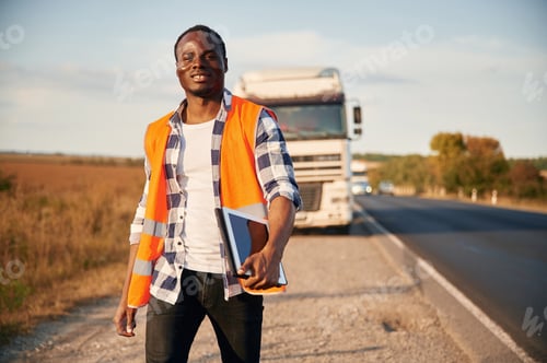 Preview: Front view. Black man is standing on the road with truck on it