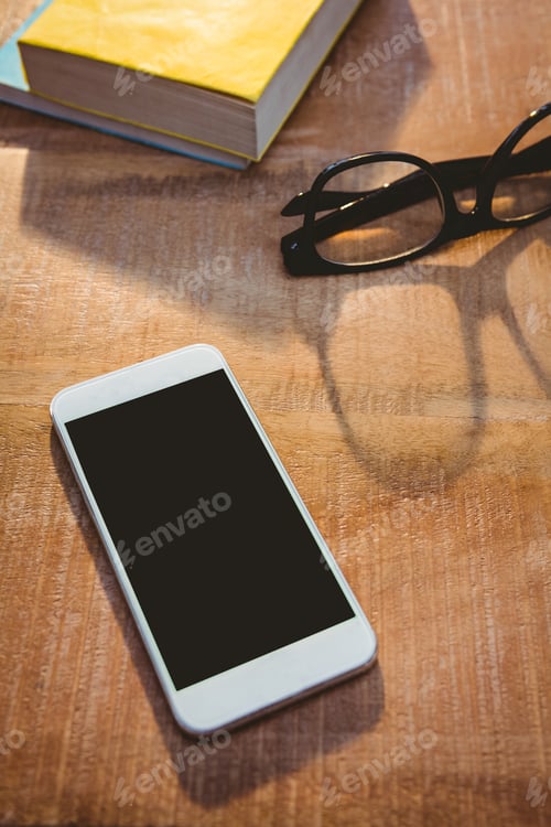 Preview: Close up view of smartphone and glasses on wood plank
