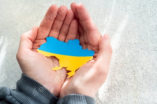 Preview: Hands holding national flag of Ukraine in the shape of the borders of Ukraine. Support for Ukraine