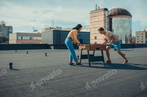 Preview: excited couple playing table football on roof
