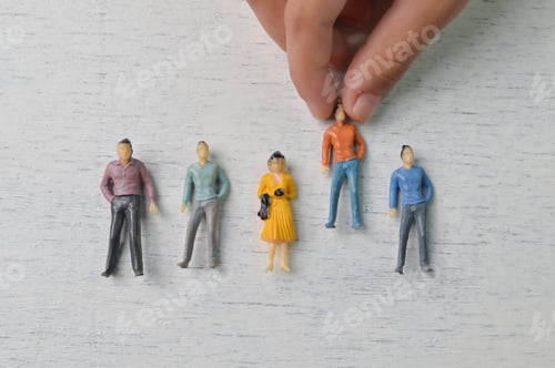 Preview: Hand grabs a people figure from the group of workers. Firing someone concept