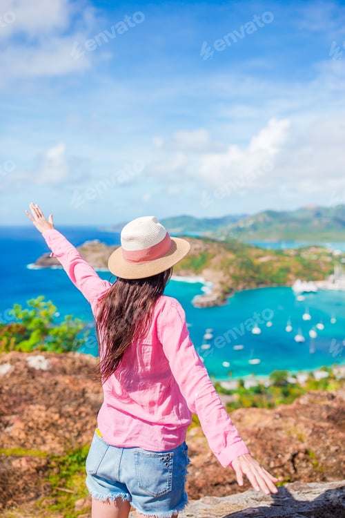 Preview: Young tourist woman with view of English Harbor from Shirley Heights, Antigua, paradise bay at