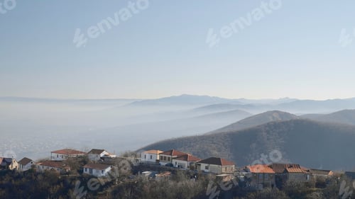 Preview: Low clouds and old houses on sunny day. Action. Old European houses on hills overlooking low fog