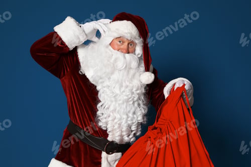 Preview: Authentic Santa Claus with bag full of gifts on blue background