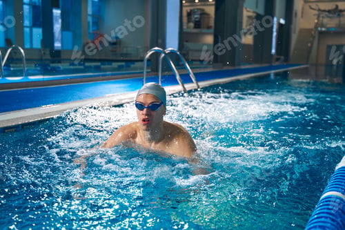 Preview: Sporty male training in pool in evening time
