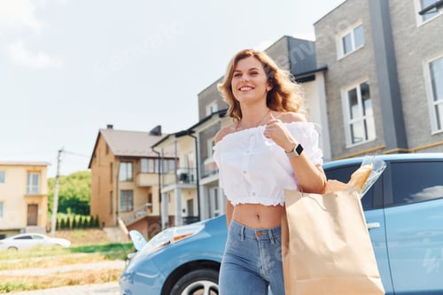 Preview: After the mall. Young woman in casual clothes with her electromobile outdoors at daytime