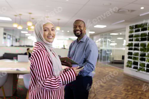 Preview: Happy diverse female and male businesspeople looking at camera in office