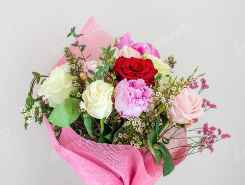 Preview: Bouquet of colorful roses and peonies wrapped in pink paper is waiting for a celebration