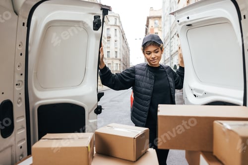 Preview: Female courier opening a car trunk doors and looking on cardboard boxes