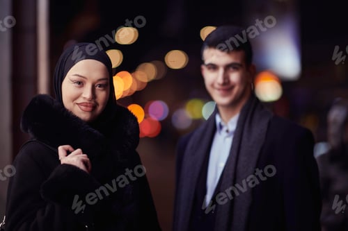 Preview: Happy multicultural business couple walking together outdoors in an urban city street at night near