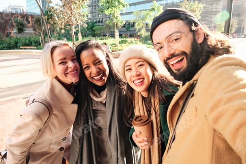 Preview: Group of business colleagues smiling while taking a selfie together outdoors during a break