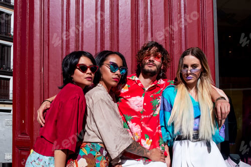 Preview: Stylish friends embracing on street