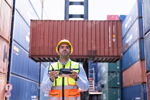 Preview: Engineer working in container storage yard fly drone looking location layout prepare to delivery