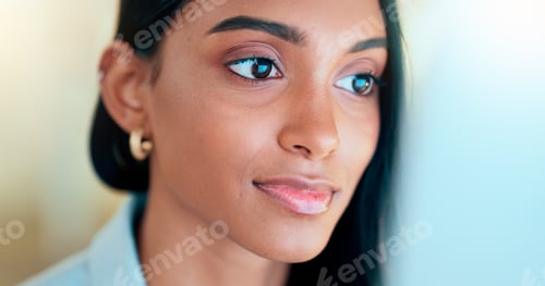 Preview: Business woman reading information on a computer screen while working in an office. Closeup on face