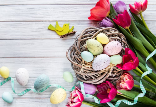 Decorated Easter Eggs and Tulips on Wooden Table