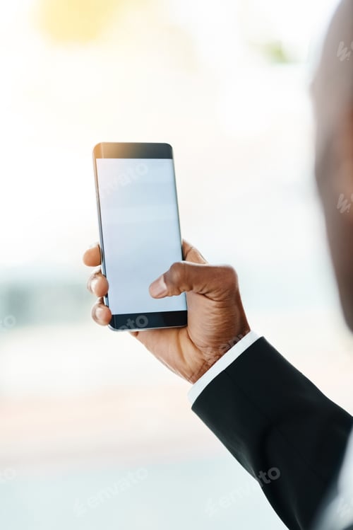 Preview: Closeup shot of an unrecognizable businessman using a cellphone in an office