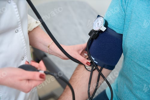 Preview: Cropped photo of doctor measuring blood pressure of man in clinic