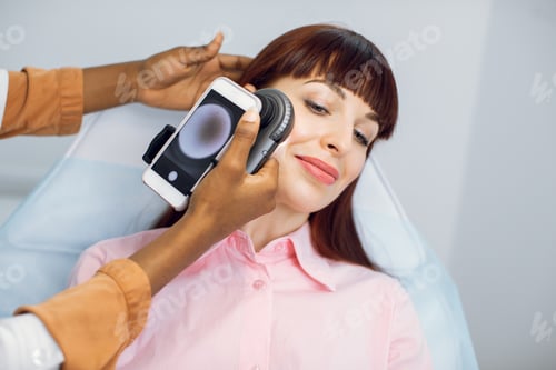 Preview: Checking of moles and birthmarks on face in modern dermatology clinic. Close up of girl patient