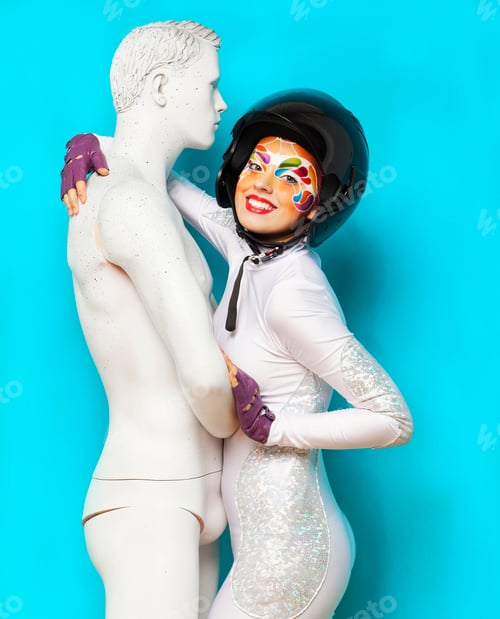 Preview: Model with bright creative make up with helmet and male dummy