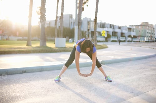 Preview: Woman wearing sports clothes hands together bending forwards stretching
