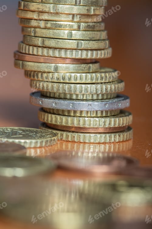 Preview: Vertic shot of a pile of gold and bronze coins on wooden surface
