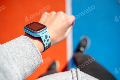 Preview: Hand with smartwatch while running on sports stadium