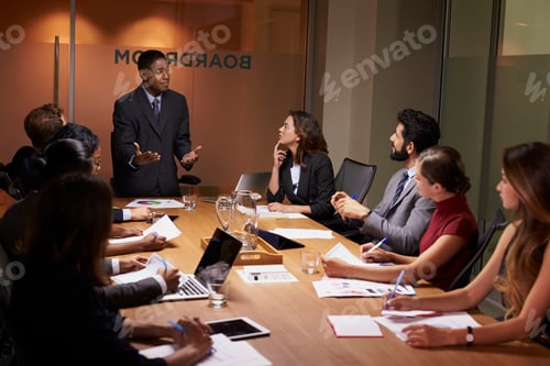 Preview: Black businessman standing to address colleagues at meeting