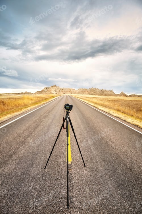 Preview: Professional photo equipment on an empty road at sunset.