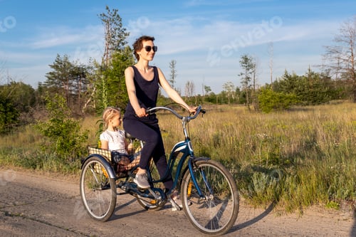 Preview: Young adult caucasian mom enjoy having leisure fun riding bicycle with cute adorable blond daughter