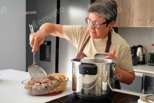 Preview: Mature Spanish woman cooking cocido, typical Spanish dish.