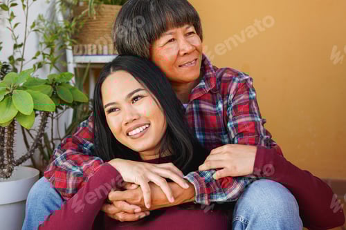 Preview: Portrait of happy asian mother and daughter having tender moment sitting outside of house
